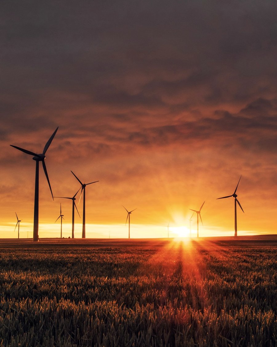 Wind turbines against a sunset